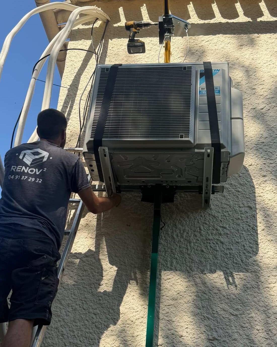 Technicien Rénov au Carré posant une unité extérieure Daikin multi-split en façade, à Marseille