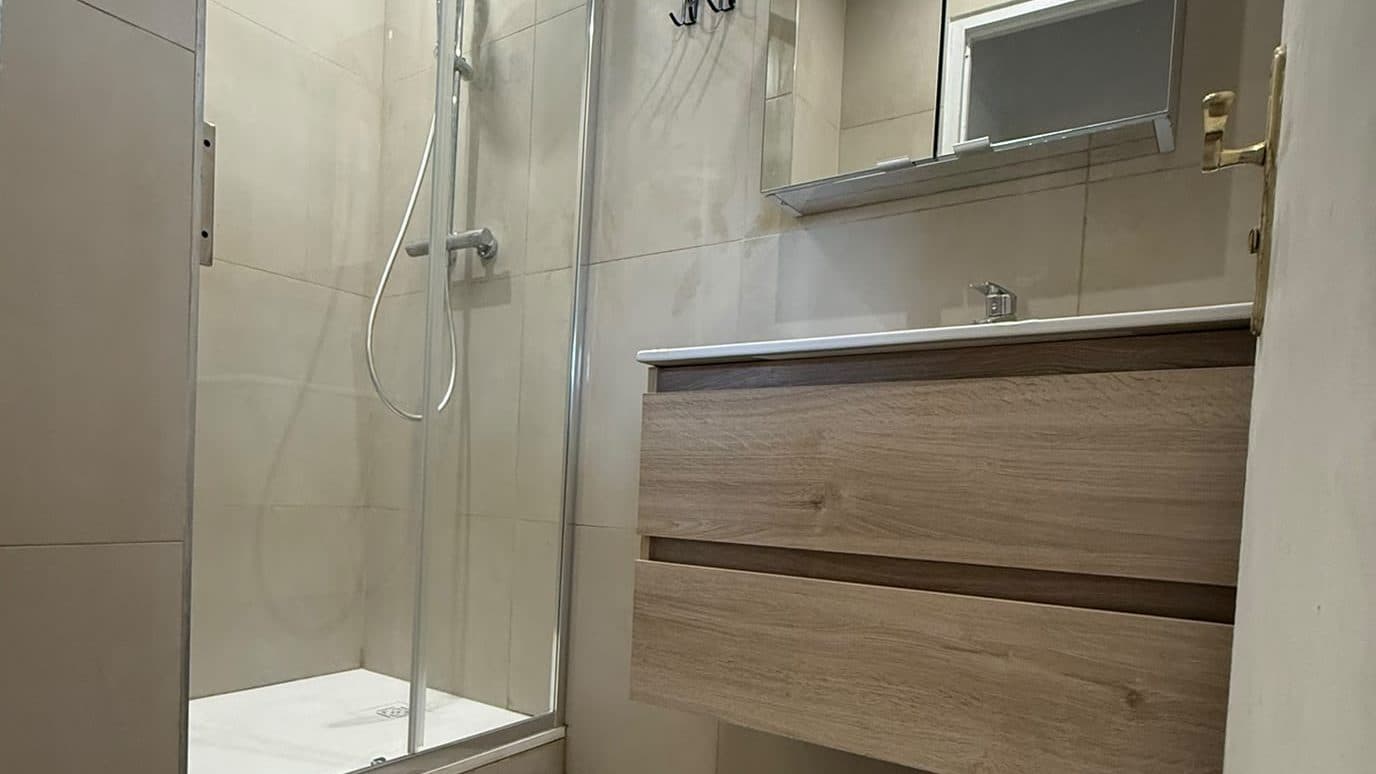 Salle de bain rénovée par Rénov au Carré : douche vitrée et meuble vasque